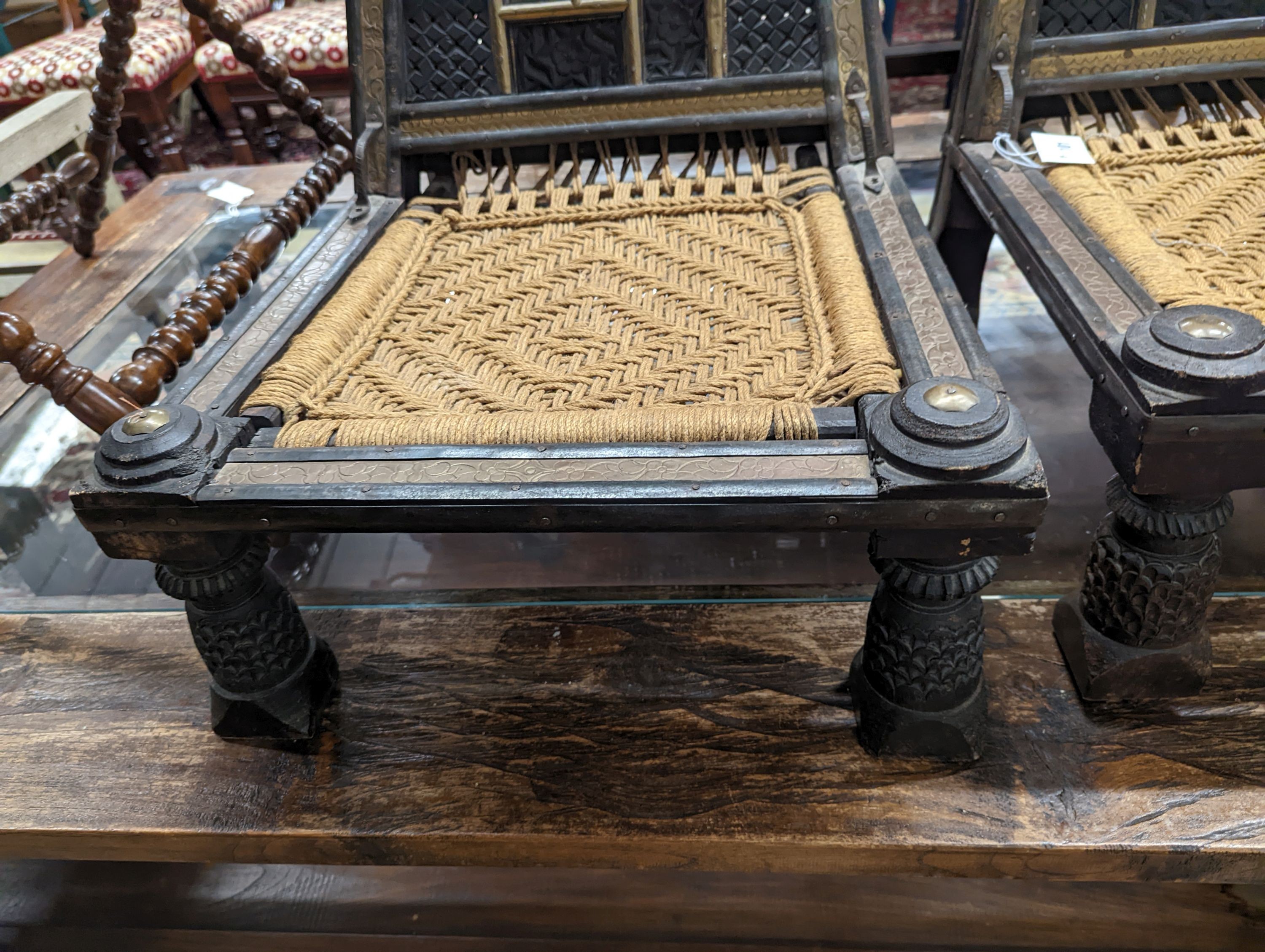 A pair of Afghan chip-carved and brass-mounted low seat chairs with woven seats, width 45cm, depth 45cm, height 76cm